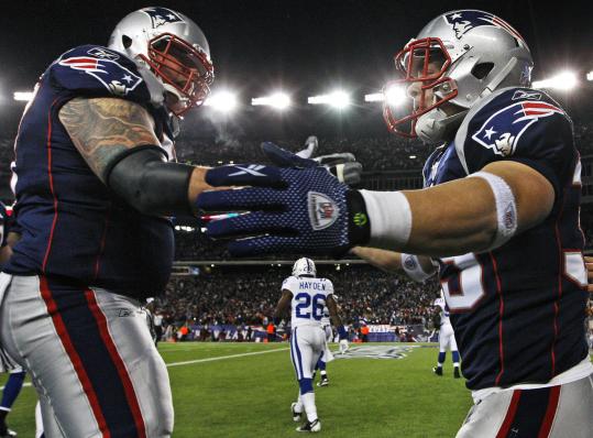 Patriots running back Danny Woodhead (right) is congratulated by center Dan Koppen after his touchdown run in the third quarter Sunday. Receivers Deion Branch and Wes Welker threw blocks to help spring Woodhead.