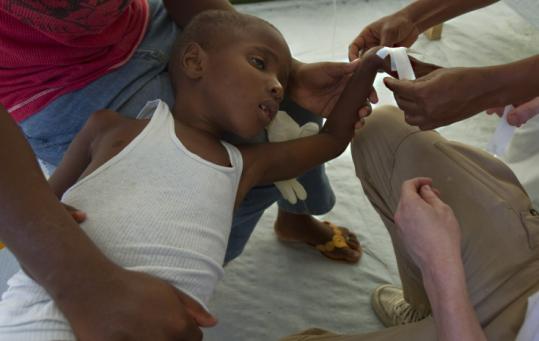 A boy suffering from cholera was treated in Port-au-Prince, Haiti, yesterday. Thousands have been sickened by the disease.