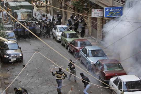 Young men threw rocks at police, who fired rubber bullets and tear gas during a protest outside Saints Church in Alexandria, the site of a bombing Saturday.
