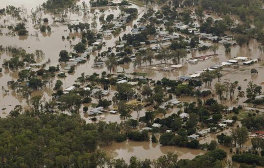 Houses were partially submerged yesterday in Queensland, Australia. Authorities say about 200,000 people have been affected.