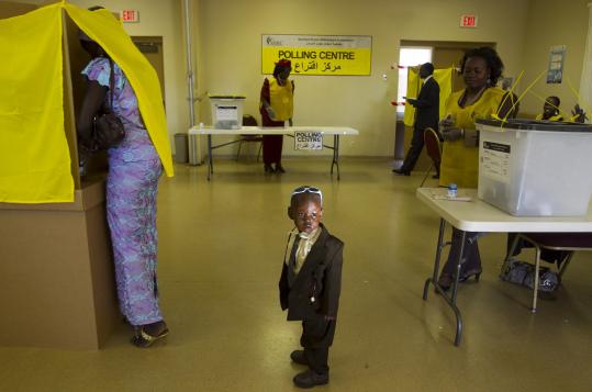 Daniel Chol, 2, waited in St. James Church in Glendale, Ariz., as his mother, Josephena Thal (left) prepared her ballot.