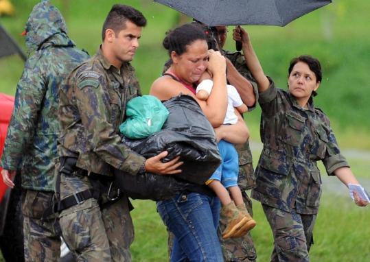Brazilian Air Force members yesterday helped a woman and her child rescued from the mudslides north of Rio de Janiero.