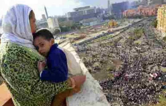 An Egyptian mother held her child as she watched thousands of protesters gather at Tahrir Square in Cairo.
