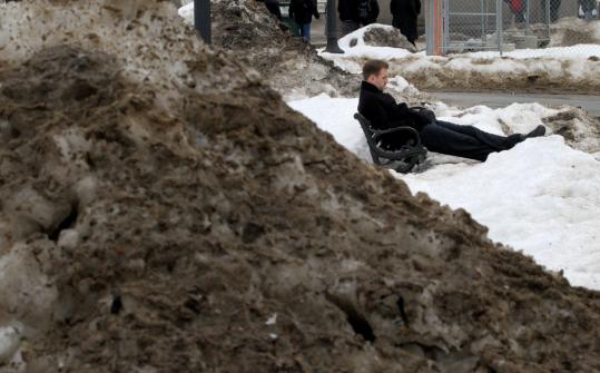 Dirty snowbanks lined Boston Common yesterday as Andrew Zoll of Clinton relaxed during his lunch break. Scenes were similar across the region.