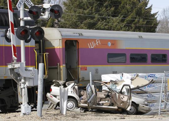 A wrecked car sat at the site of a late-morning crash on the commuter rail tracks at East High Street in Avon. The driver was taken to a hospital with injuries that were not life-threatening.