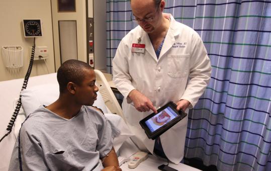 Dr. Henry Feldman used an iPad to show endoscopy results to patient Courtney Williams.