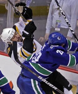 The Bruins’ Milan Lucic appears to need a fallback plan after a collision with the Canucks’ Aaron Rome in the first period.