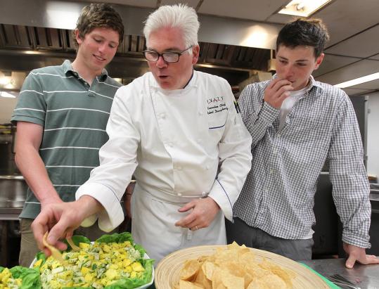 Robert Daugherty, executive chef at the Hyatt Regency Cambridge, at work in the hotel’s kitchen during a visit from his sons, Matthew, 19, (left) and Benjamin, 18.