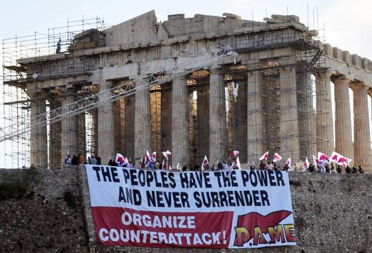 A Communist trade union protested yesterday atop the Acropolis archeological site, condemning the austerity package officials say must pass to get Greece a second bailout. Parliamentary debate on the unpopular package is to wrap up with a vote today.