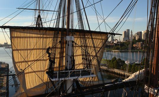 The USS Constitution, which played a vital role in the War of 1812, is shown in full rigging with its top masts in the old Charlestown Navy Yard.