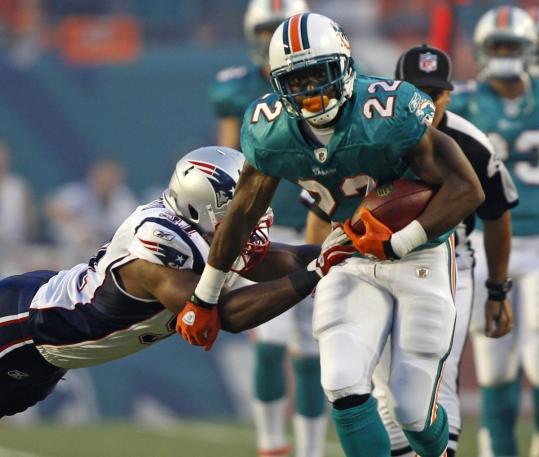 Patriots linebacker Jerod Mayo gets his mitts on Reggie Bush and drags down the Miami running back in the first quarter.