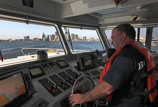 Boston firefighter Ralph Dean was at the helm of the John S. Damrell, the city’s new firefighting vessel, during a training run yesterday in Boston Harbor.
