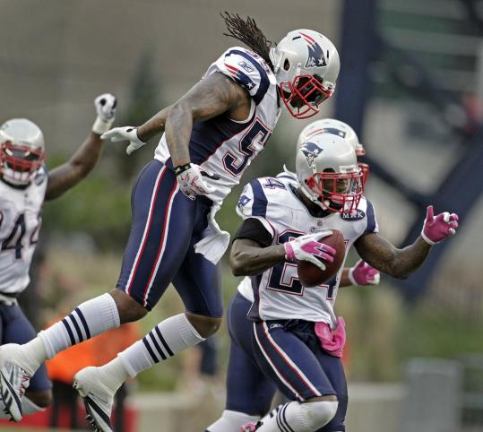 Brandon Spikes’s zest for the game is evident after an interception by Kyle Arrington (right).