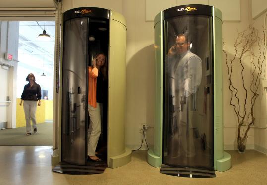 Margaux Stunzi (left) and Tony Cotrupi make cellphone calls in soundproof booths.