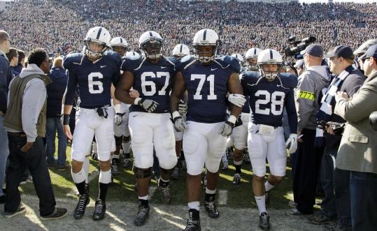 Penn State players Derek Moye, Quinn Barham, Devon Still, and Drew Astorino linked arms as they led the team onto the field before yesterday’s game against Nebraska in State College, Pa.