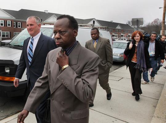 Onyango Obama and his lawyer, P. Scott Bratton (left), were followed by journalists after a pretrial hearing in Framingham District Court.