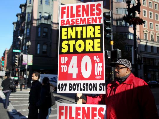 Allen Newson held up an advertisement at the corner of Boylston and Berkeley streets yesterday. Filene’s Basement is holding liquidation sales.