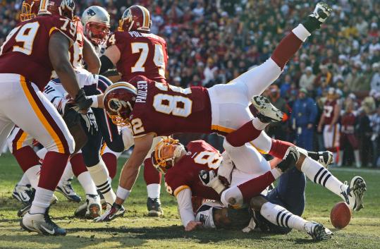 Redskins quarterback Rex Grossman (8) is stripped of the ball - and some of his dignity - by Andre Carter on the play that led to Vince Wilfork’s first touchdown.