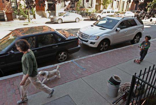 These two parking spaces in Boston could become a parklet - a tiny patio with benches and planters.