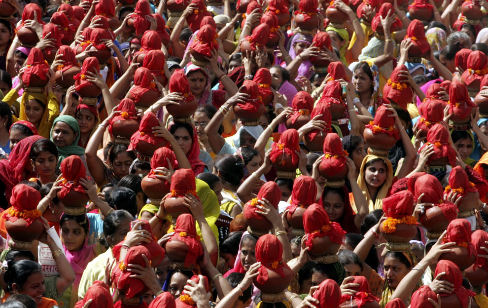 People carry earthen water pots as they take part in a Jhulelal Chaliha