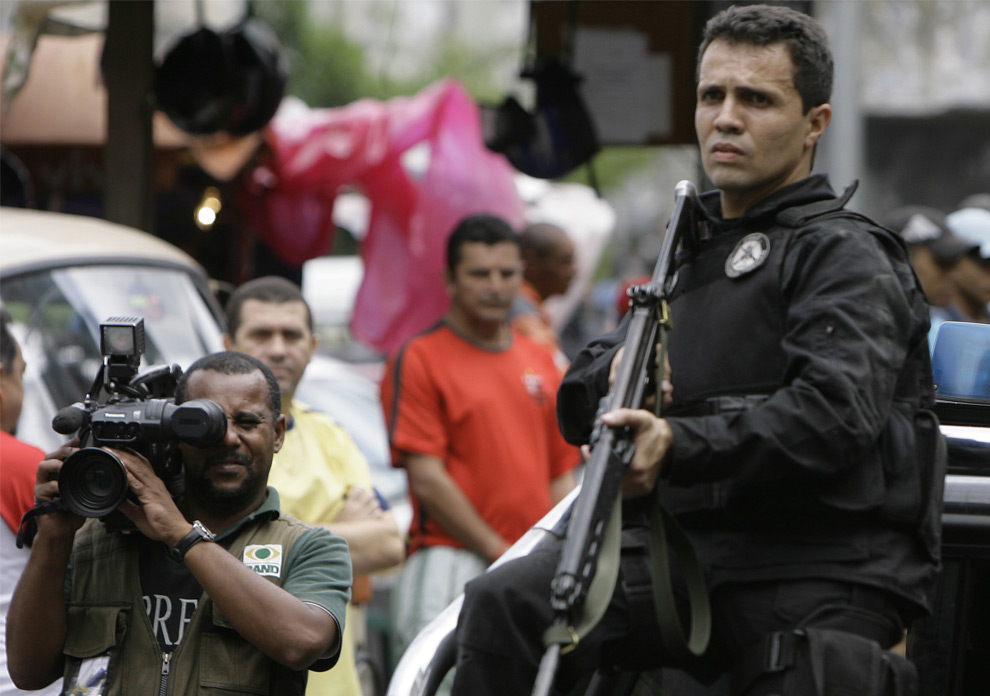 Оператор снимает полицейскую операцию на улицах трущоб Rocinha в Рио-де-Жанейро, 2 июня 2008. Два бразильских журналиста, проводивших расследование в трущобах Рио-де-Жанейро утверждают, что были похищены и подвергнуты пыткам со стороны вооруженных людей, которые назвались полицейскими, сообщает газета «O Dia». (AP Photo/Ricardo Moraes)