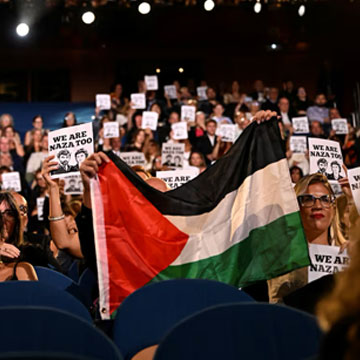 Attendees hold signs in support of NAZA documentary film